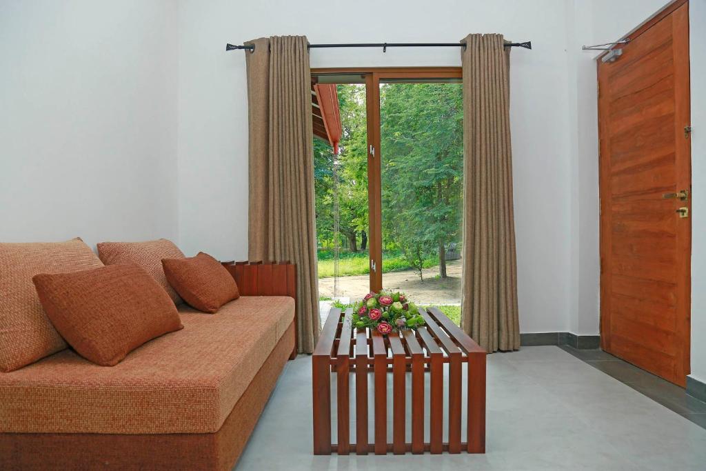 salon z kanapą i oknem w obiekcie The Forest Chalet w mieście Tissamaharama