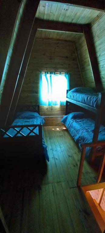 a attic room with two bunk beds and a window at Ventana al Champaqui in Yacanto