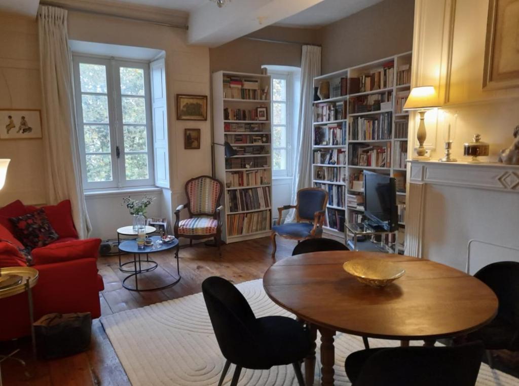 un salon avec une table, des chaises et des étagères dans l'établissement Appartement darmateur port de vannes 17 eme siècle, à Vannes