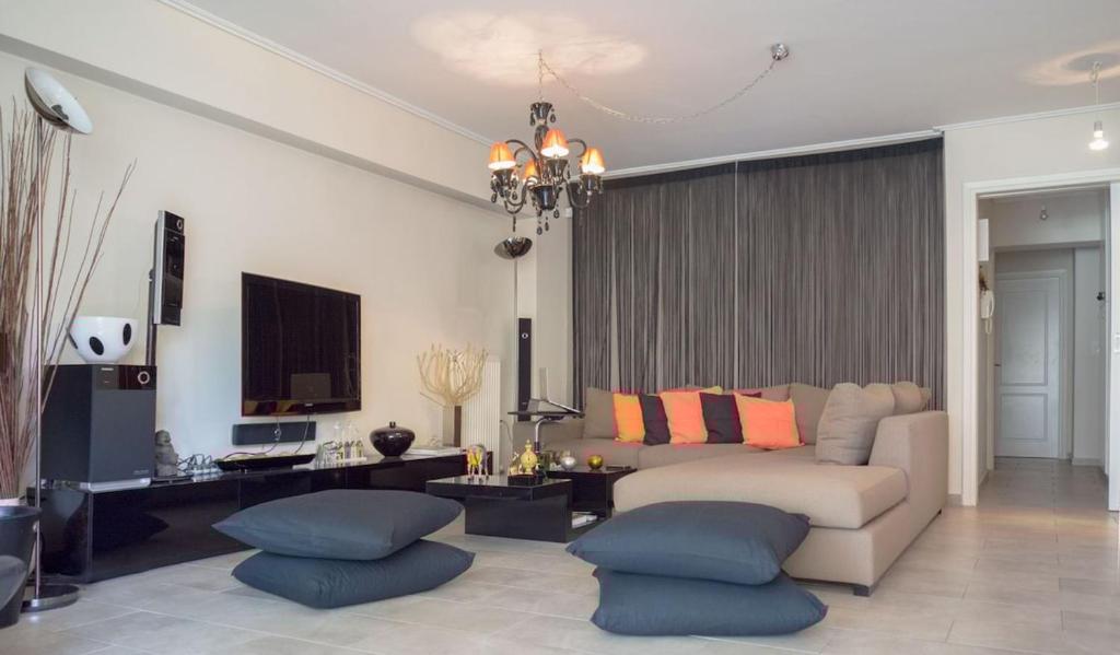 a living room with a couch and some blue ottoman at Designers apartment in Galatsi area in Athens