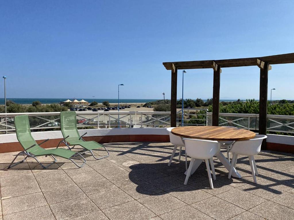 un patio avec une table et des chaises sur un toit dans l'établissement PLEIN SUD 2 VUE MER, à Narbonne-Plage