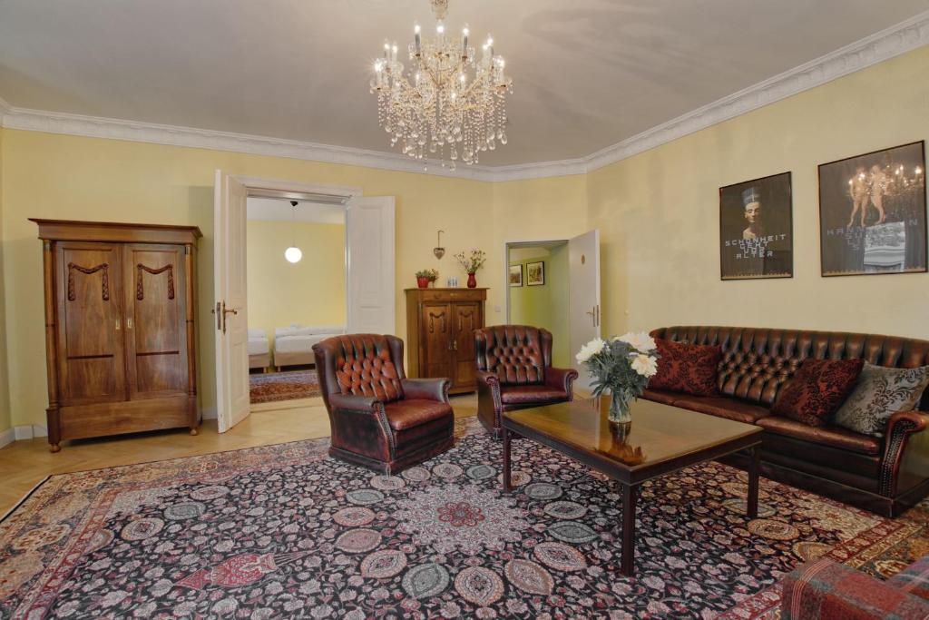 a living room with a couch and chairs and a table at Holiday Berlin Apartments in Berlin