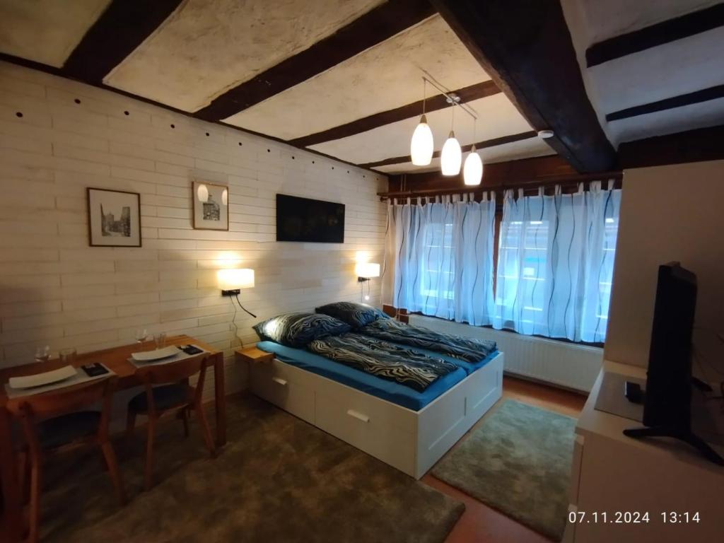 a bedroom with a bed and a table and a dining room at Gemütliche Erdgeschosswohnung im historischen Fachwerkhaus in Alsfeld in Alsfeld