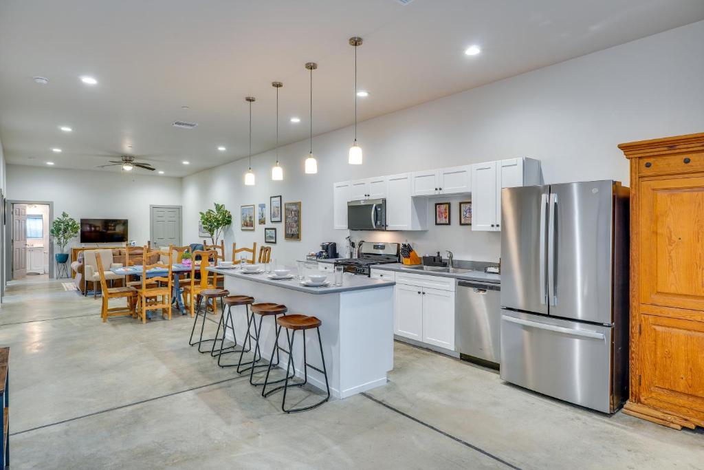 a large kitchen with white cabinets and bar stools at Game Day Hub! 1 Mi to AU and Arizona Stadium in Tucson