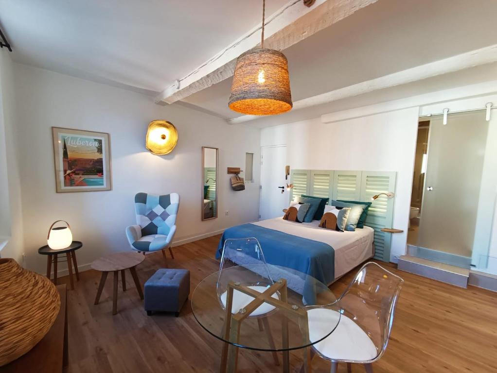 une chambre avec un lit et une table en verre dans l'établissement Centre historique studio rénové avec vue, à LʼIsle-sur-la-Sorgue