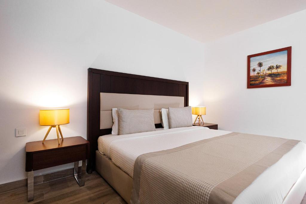 ein Schlafzimmer mit einem großen Bett und zwei Lampen in der Unterkunft Riviera Royal Hotel in Conakry