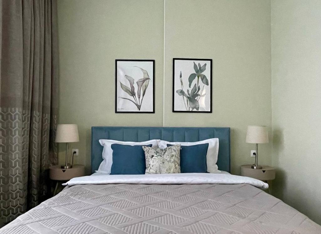 a bedroom with a bed with three pictures on the wall at GreenLine Terra in Astana