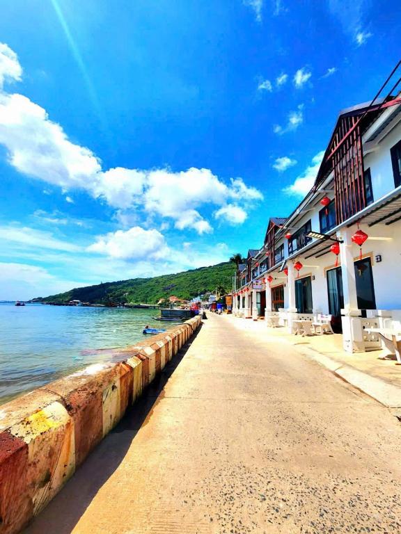 a street next to a body of water with buildings at La Maison Hòn Sơn in Lai Sơn