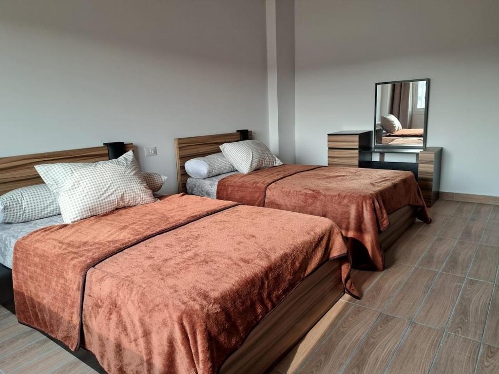 a bedroom with two beds and a mirror at New Cairo Cozy Studio استديو فندقى بالتجمع in New cairo