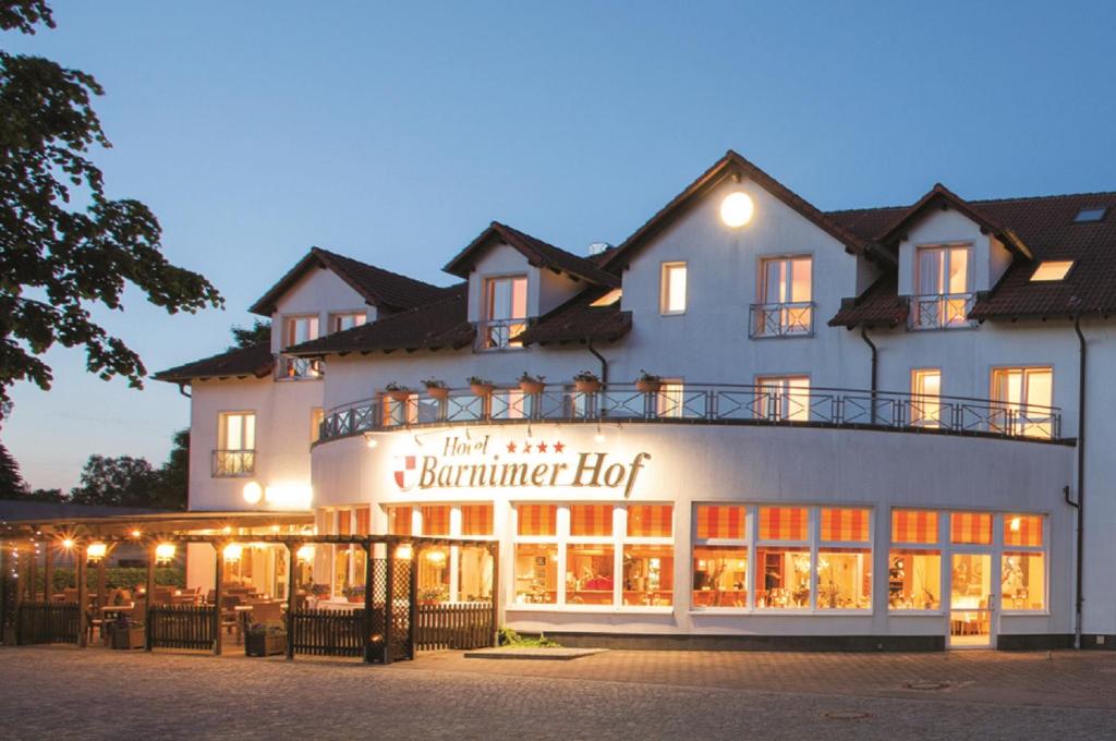 un edificio con un cartel para una hamburguesa de cerdo en Hotel Barnimer Hof, en Wandlitz