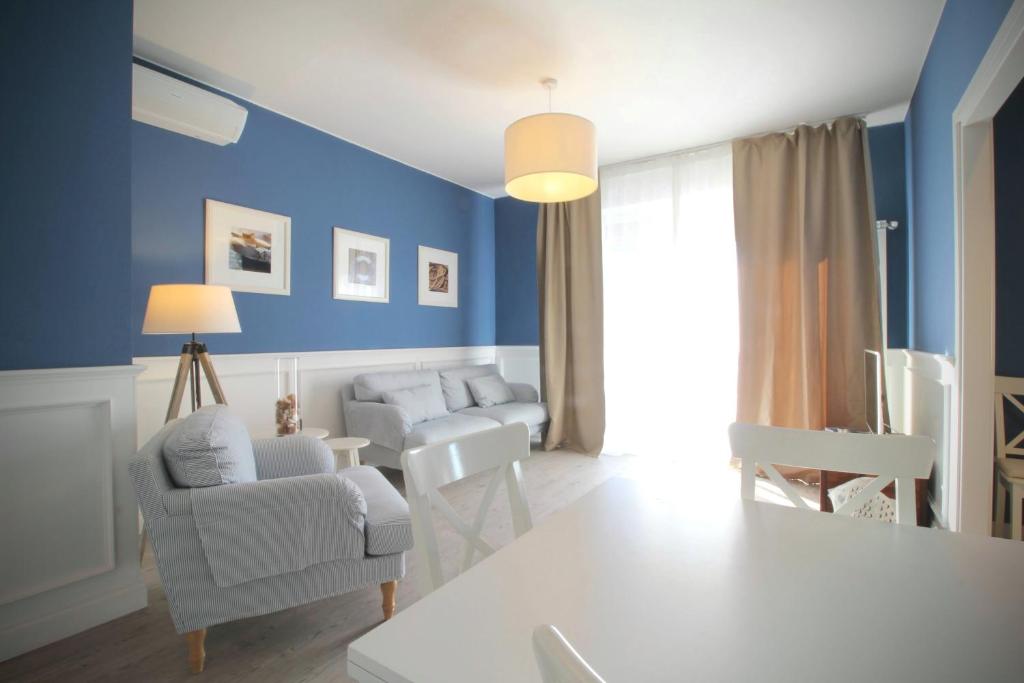 salon z niebieskimi ścianami i białymi meblami w obiekcie Le Grand Bleu w mieście Bordighera