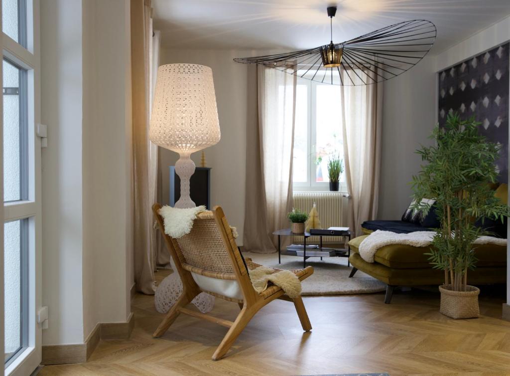 un salon avec une chaise et une lampe dans l'établissement Les deux maisons - Tolbiac - Maison 8 personnes vue pistes proche lac, à Gérardmer