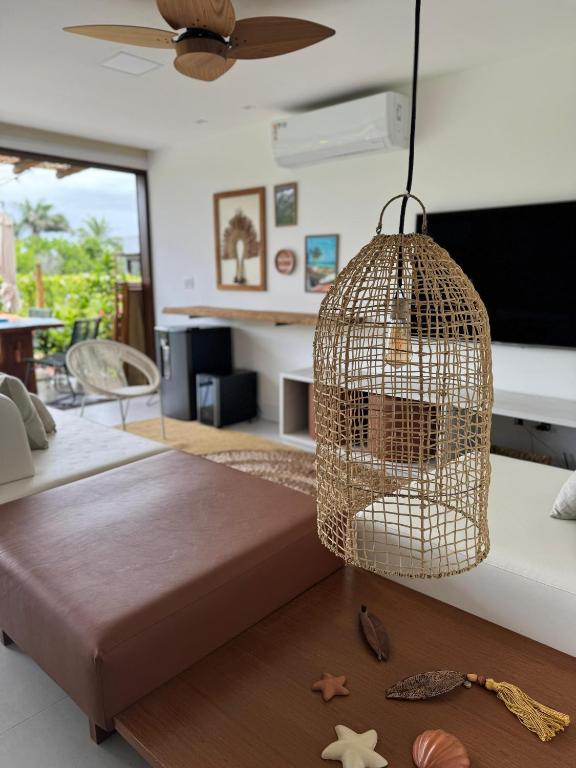 ein Schlafzimmer, in dem ein Vogelkäfig von der Decke hängt in der Unterkunft Casa Amaré Refúgio com piscina em Maraú in Marau