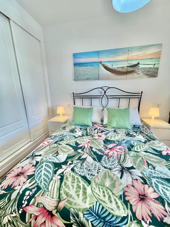 sypialnia z łóżkiem z narzutą w kwiaty w obiekcie Apartamento Narváez- Altos Del Tomillar w mieście Torre del Mar