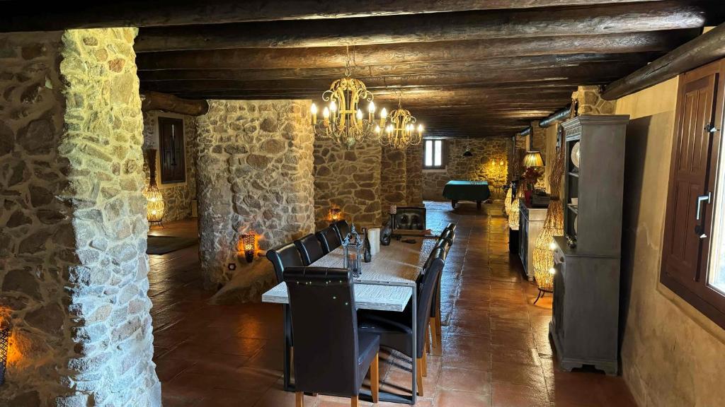 a dining room with a table and a stone wall at Finca El Corchito Aracena in Aracena