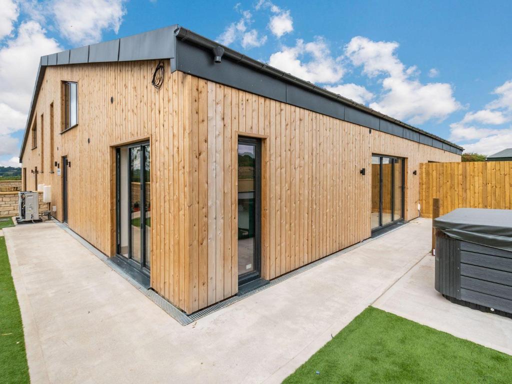 a house with wooden siding on a patio at Bears Court Barn 2 in Cheltenham