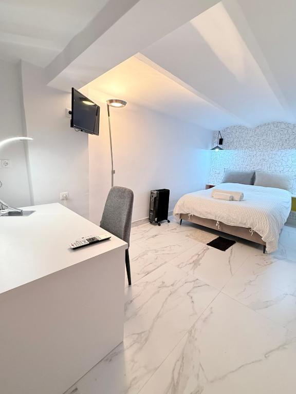 une chambre blanche avec un lit et un bureau dans l'établissement Riad-Entreplanta 2, à Melilla