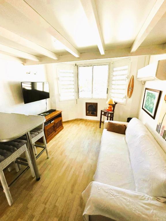 una sala de estar con un sofá y una mesa en Hibiscus Duplex Port Marina, en Saint-François