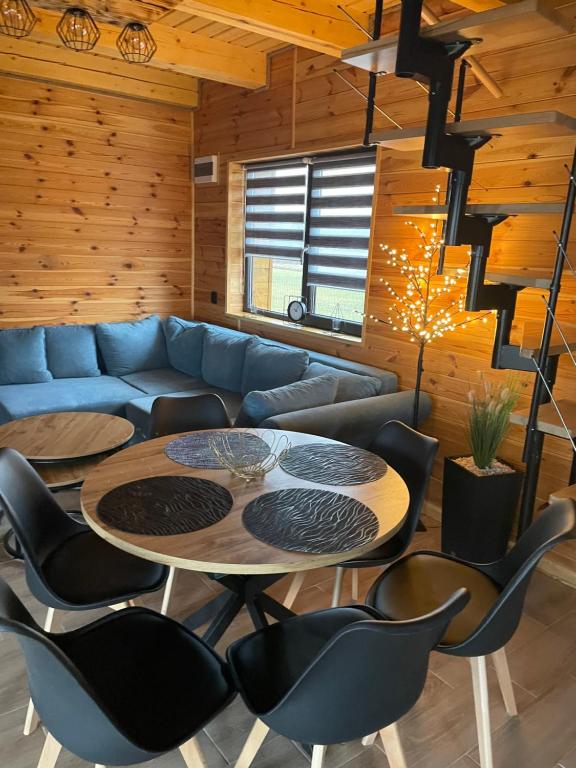 a living room with a blue couch and a table and chairs at Domek w Budzie Ruskiej in Buda Ruska