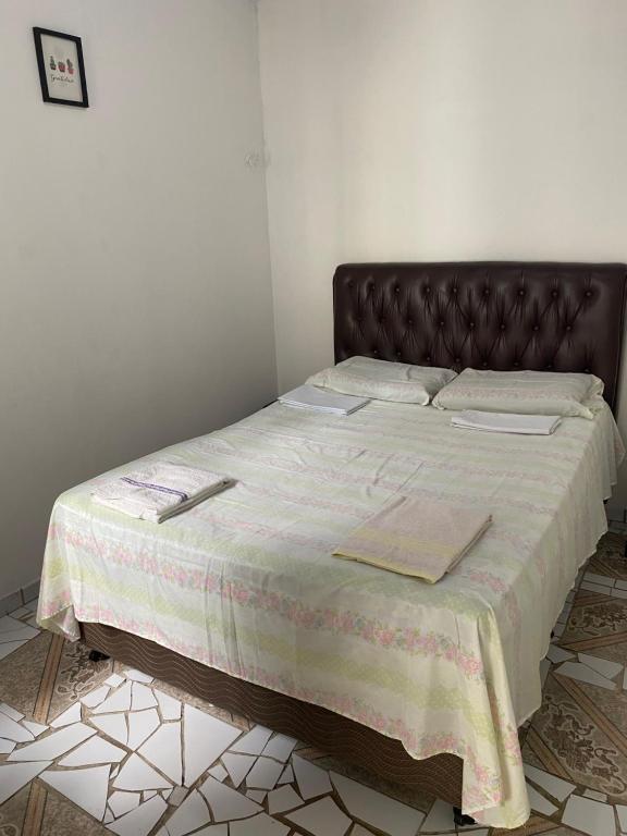 Un dormitorio con una cama con cabecero marrón. en Casa em vila familiar, en Natal