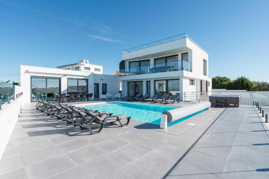 a villa with a swimming pool and a house at Villa Gold with ocean view, jacuzzi and private pool in Ribamar