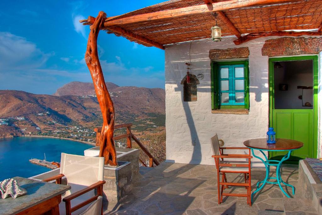 a house with a green door and a table and chairs at Pano Gitonia in Aegiali