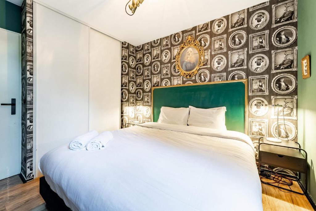 a bedroom with a large bed and a wall with plates at Family Travel Paris 4 in Bussy-Saint-Georges