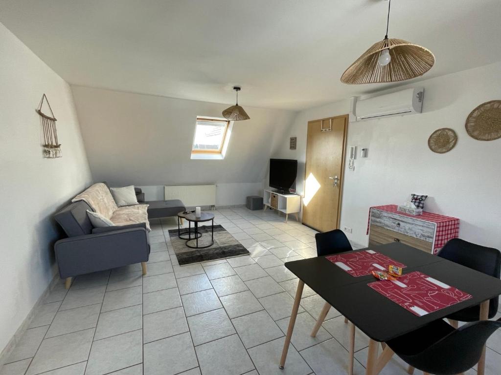 a living room with a couch and a table at Appartement Betschdorf Cité des potiers in Oberbetschdorf