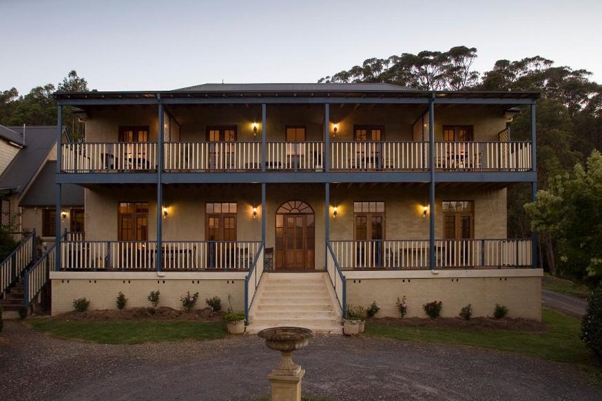 una casa grande con una escalera delante de ella en Wombatalla en Kangaroo Valley