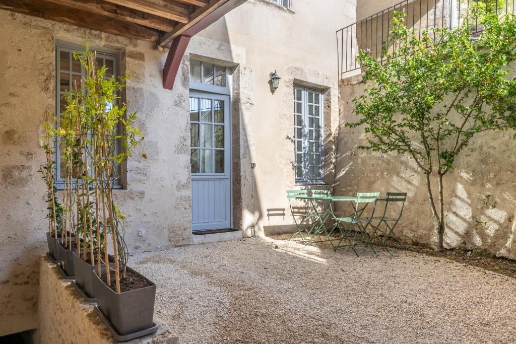 une maison avec une porte bleue et des arbres devant elle dans l'établissement L'Antre des rois - place de parking, à Blois