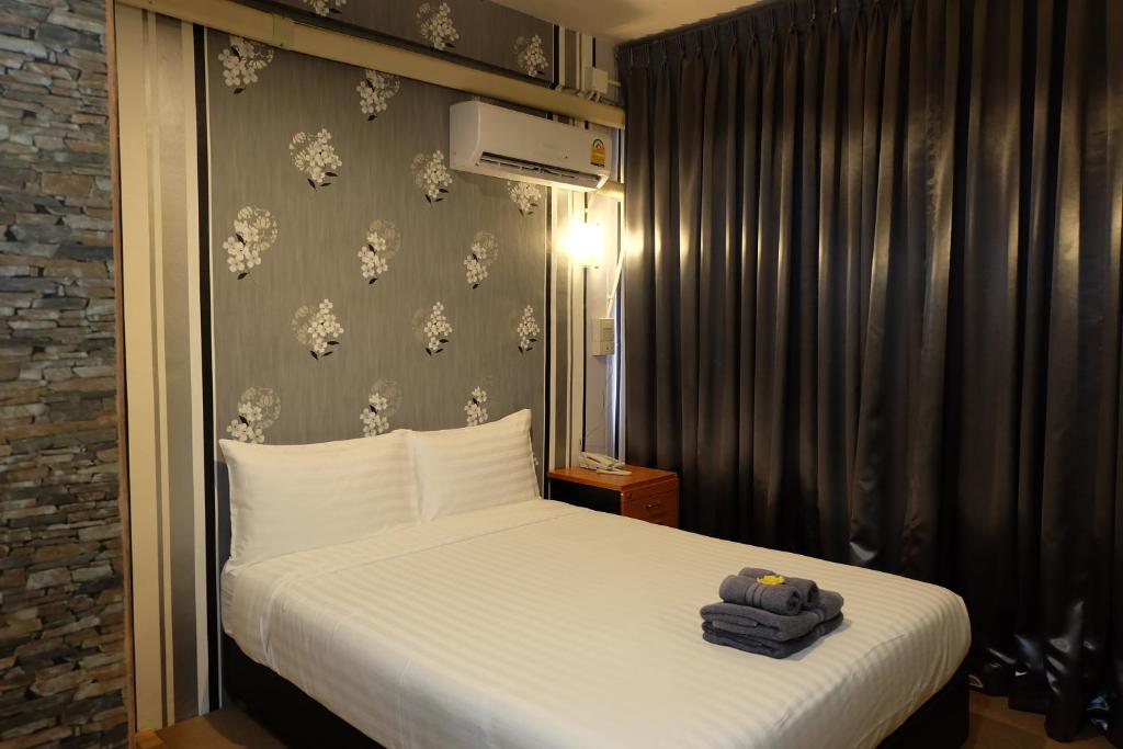 een hotelkamer met een bed met een koffer erop bij Decordo Hostel in Bangkok