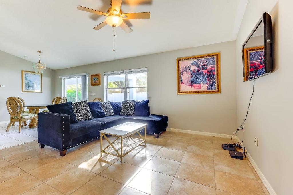 a living room with a blue couch and a ceiling fan at Pet-Friendly Palm Coast Home 8 Mi to Beach! in Palm Coast