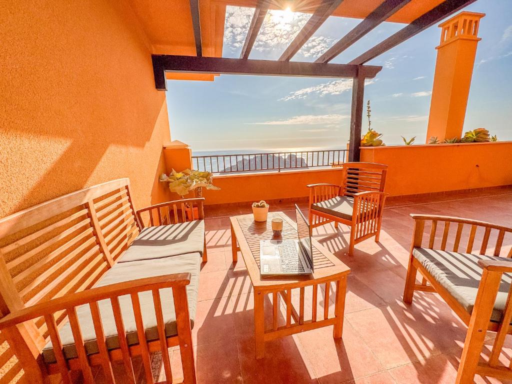 a patio with tables and chairs on a balcony at MIRADOR del Paraiso - By Aloha Palma in Águilas