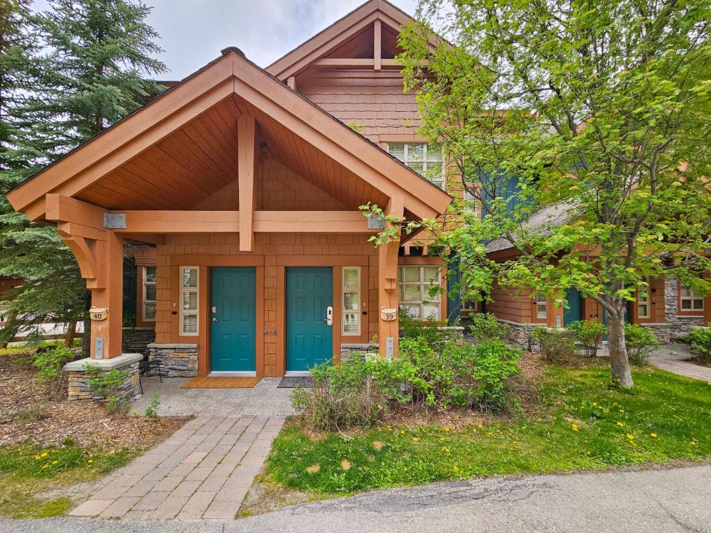 a wooden house with a blue door in a yard at Riverbend Townhomes by StayIn in Panorama