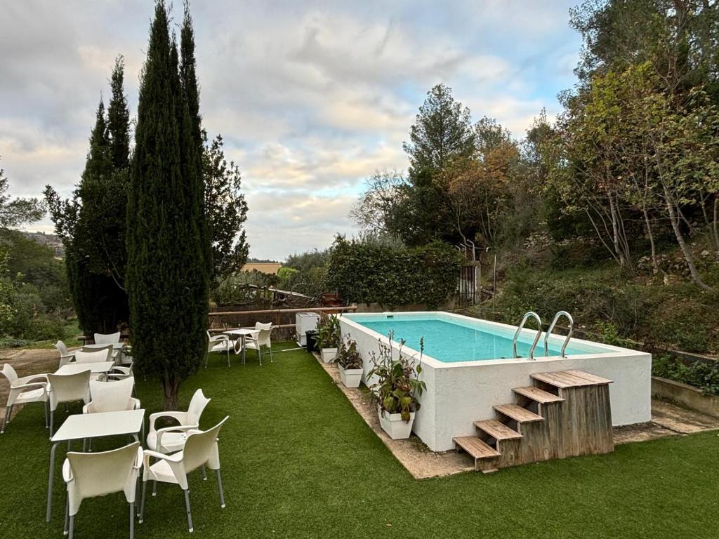 a swimming pool with chairs and a table at Paraiso Natural Unico -Villa Cueva Turche in Valencia