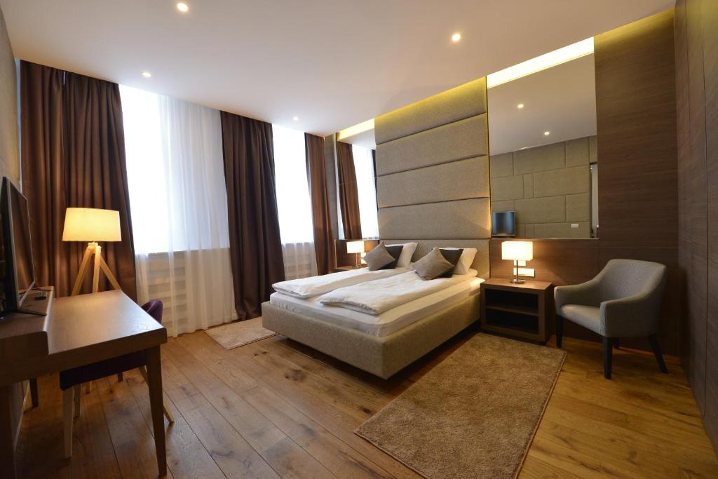 a bedroom with a bed and a desk and a mirror at Boutique Rooms in Belgrade