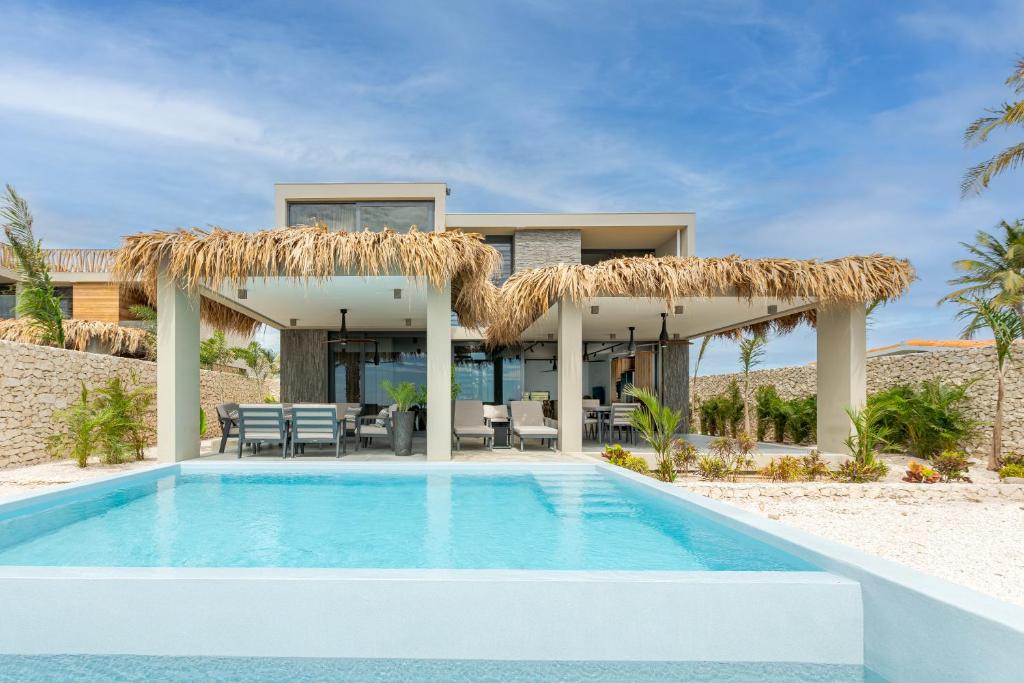 a villa with a swimming pool and a resort at Delfins Residences in Kralendijk