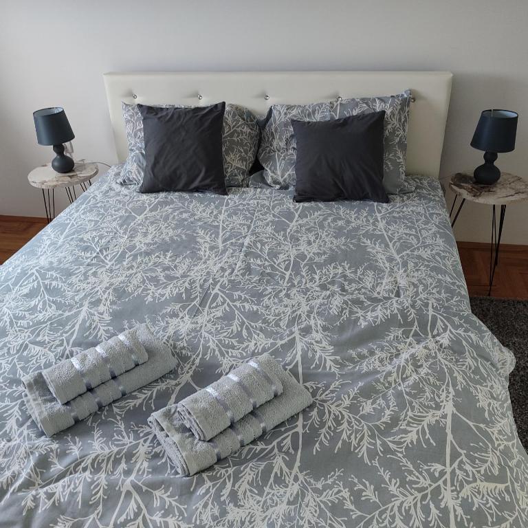 uma cama grande com duas almofadas em Apartman N&L em Sombor
