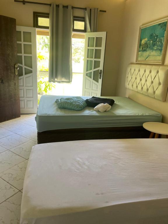 een slaapkamer met 2 bedden, een raam en een tafel bij House stella maris in Salvador