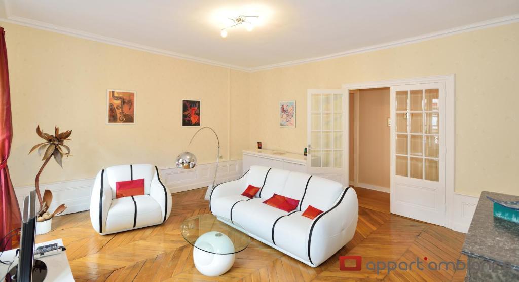 a living room with two white chairs and a table at Appart' Odeon in Lyon