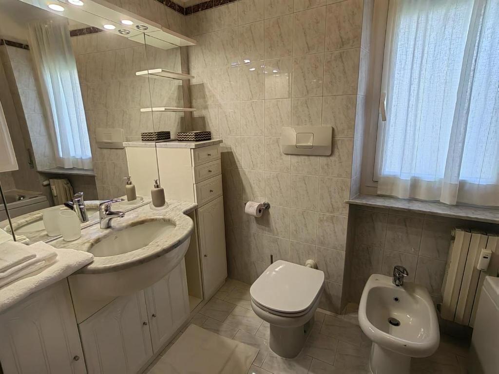 a white bathroom with a sink and a toilet at Il maestrale vacation house in Genova