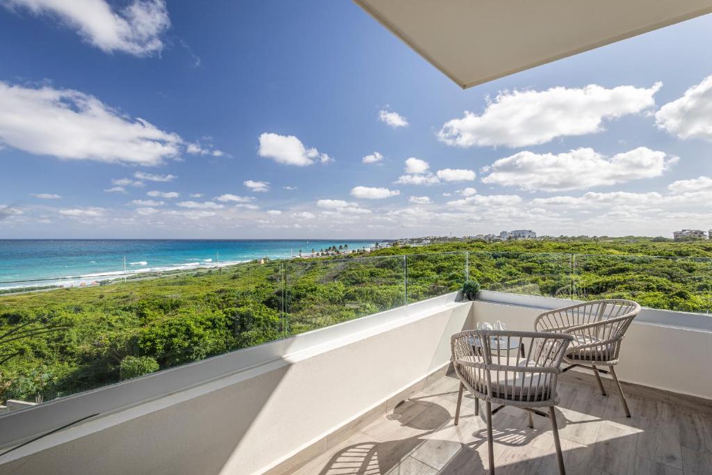 a balcony with two chairs and a view of the ocean at Azulea Isla Mujeres Hotel in Isla Mujeres