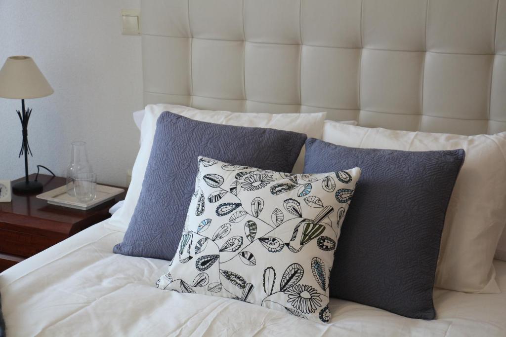 1 cama con 2 almohadas y colcha blanca en Apartamento Homelife Toletum, en Toledo