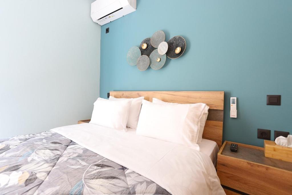a bedroom with a bed with a blue wall at City center apartment in Nafpaktos
