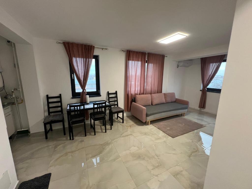 a living room with a couch and a table and chairs at Everest 33 Ap 4 in Bucharest