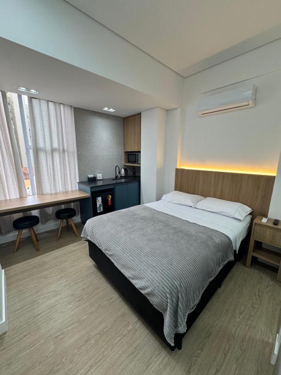 a bedroom with a bed and a desk in it at Studio no centro, confortável e prático in Florianópolis