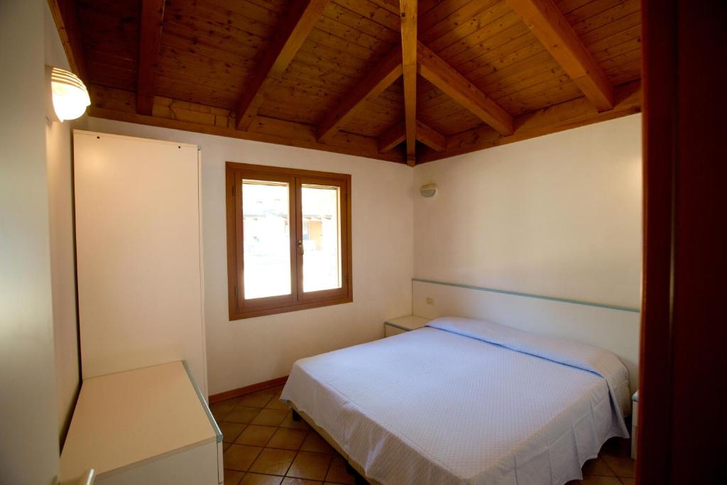 En eller flere senger på et rom på Belvedere Pineta Camping Village Grado