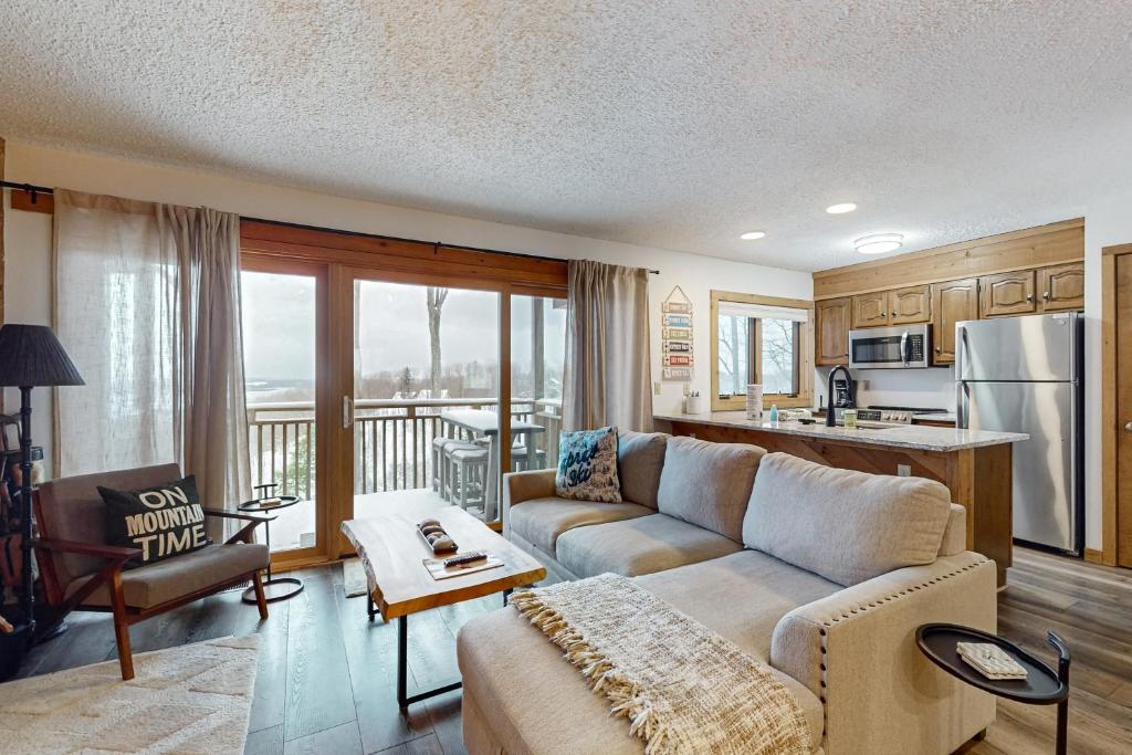 a living room with a couch and a kitchen at Snowshoe Condo in Bellaire