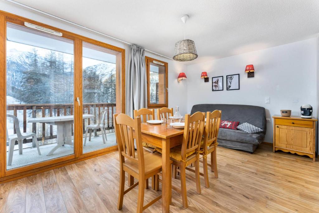 une salle à manger avec une table, des chaises et un canapé dans l'établissement Les Chalets De Bois MÉan - B - Chaleureux appartement avec vue dégagée MAE-5251, aux Orres