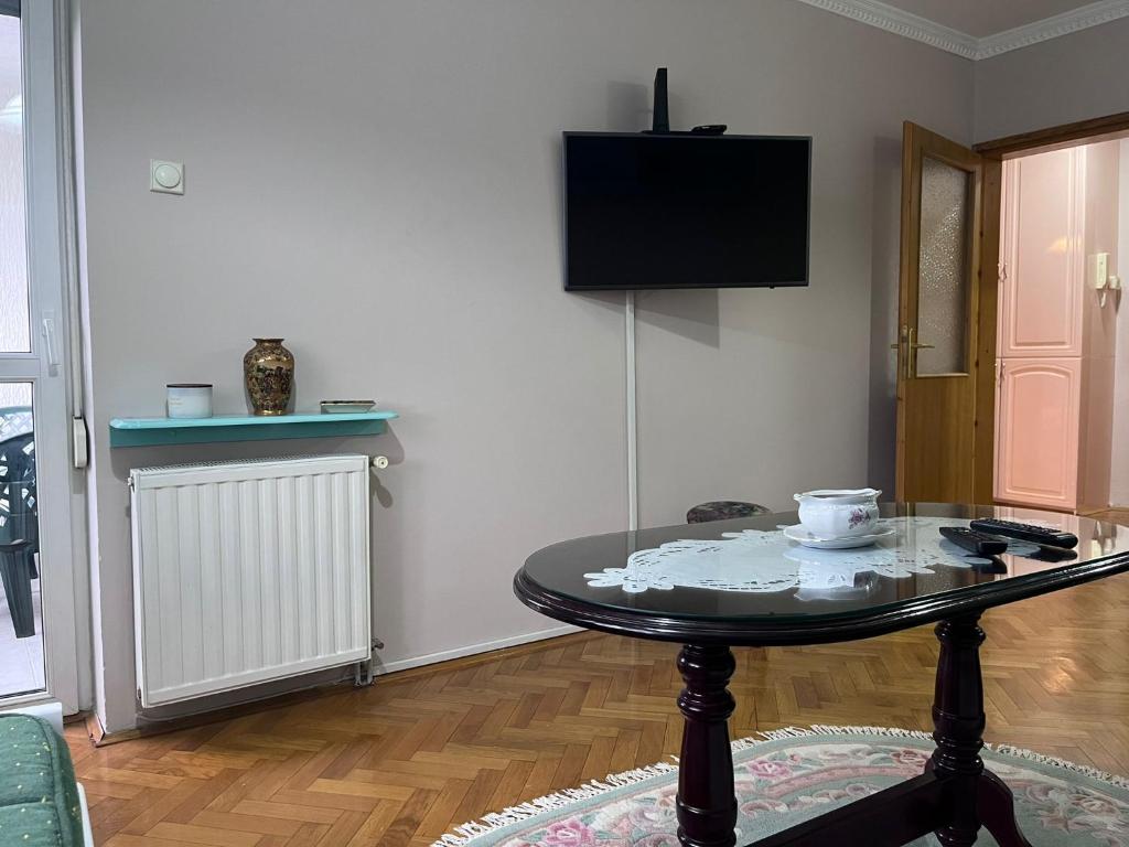 a living room with a table and a tv at Apartman Ivanka in Zlatibor